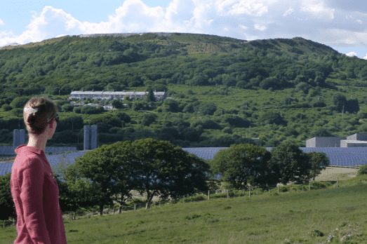 Person looking out over hills and solar panels