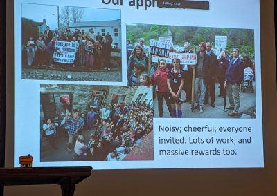 Image of a slide with photos of people holding signs saying "Save the Old Ship Inn". Slide reads "Our Approach: Noisy, cheerful, everone invited. Lots of work and massive rewards too.