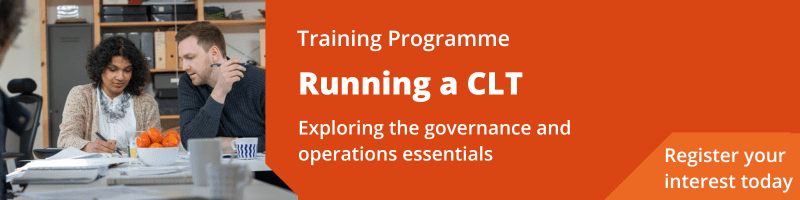 Image of two people at a board meeting table - one person is writing with a pen and the other is leaning over saying something. Text reads Training programme: Running a CLT - Exploring the governance and operations essentials