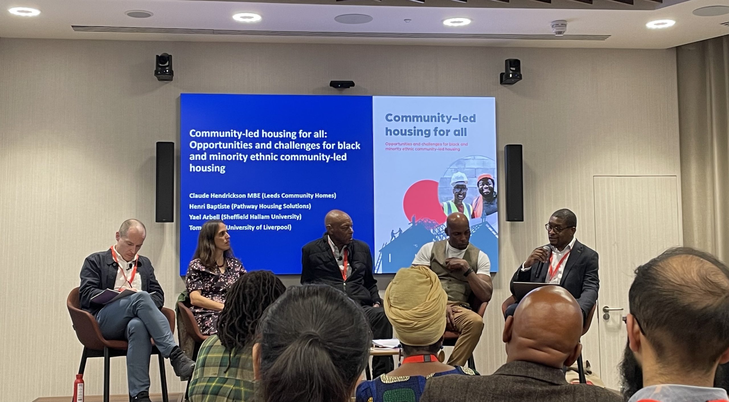 Five people on stage discussing the research findings